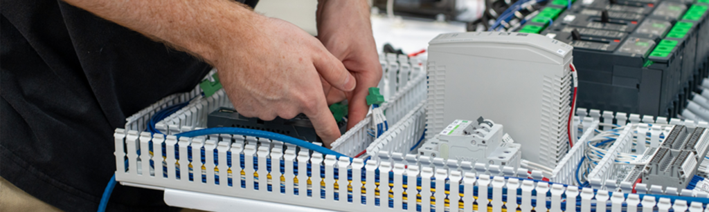 Man working on wiring of control panel.