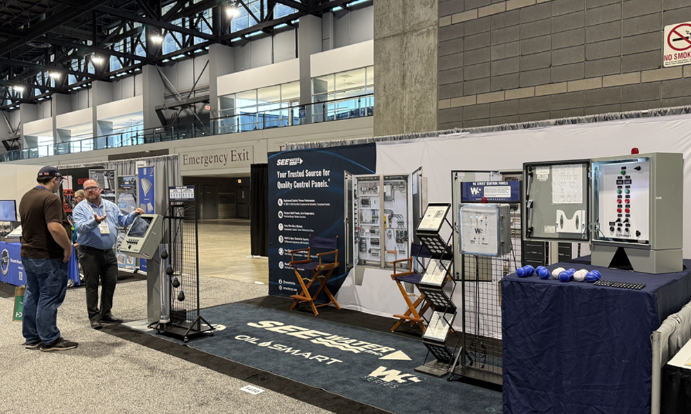 Two men talking in front of tradeshow booth.