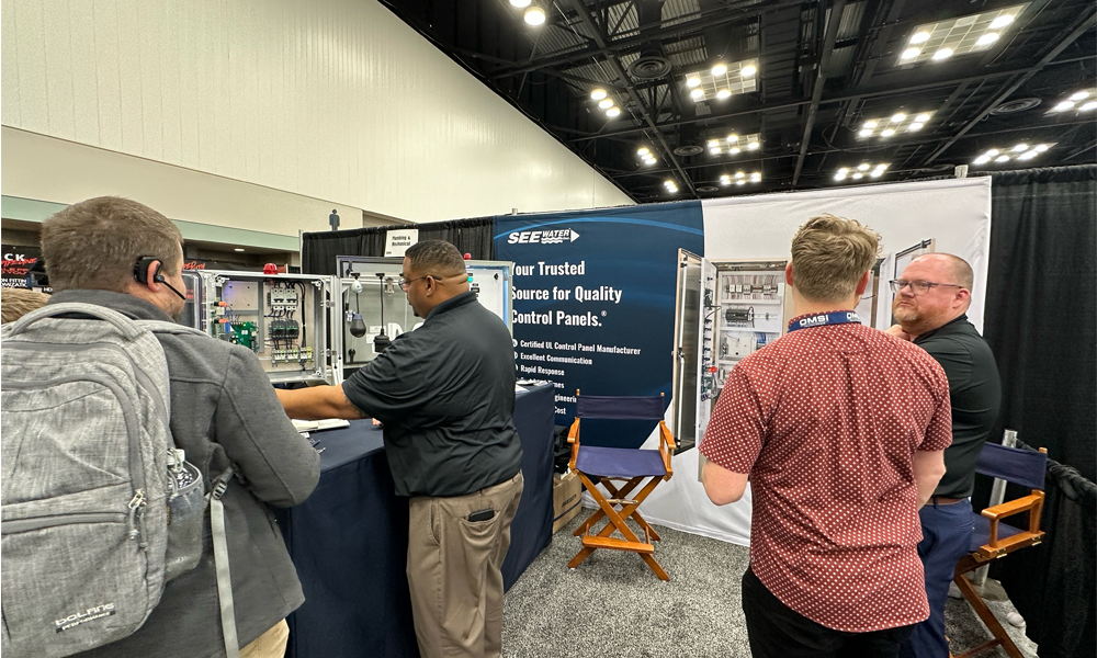 A group of people talking at tradeshow booth.